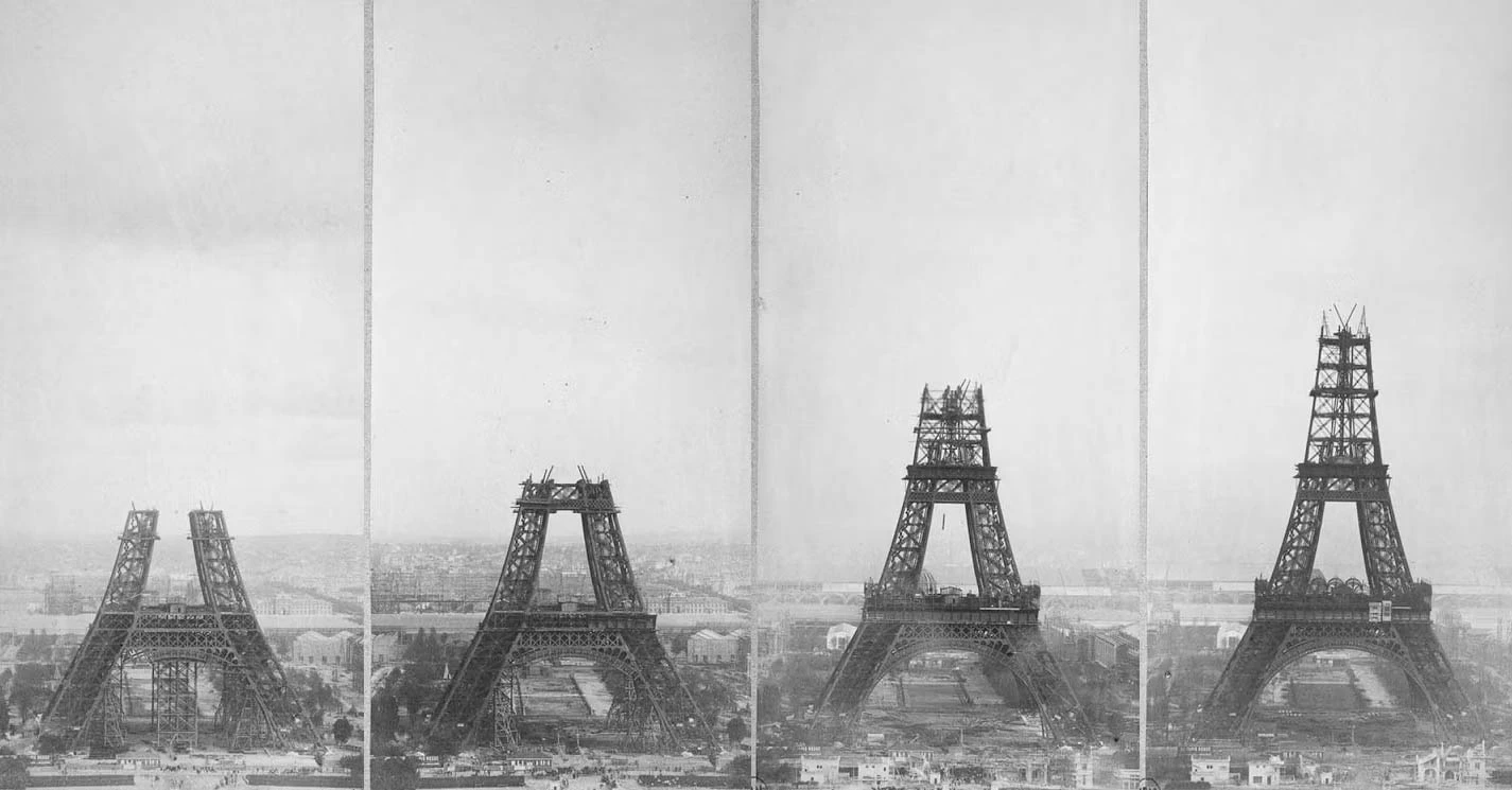 Eiffel Tower base seen from below, revealing the complex network of iron beams